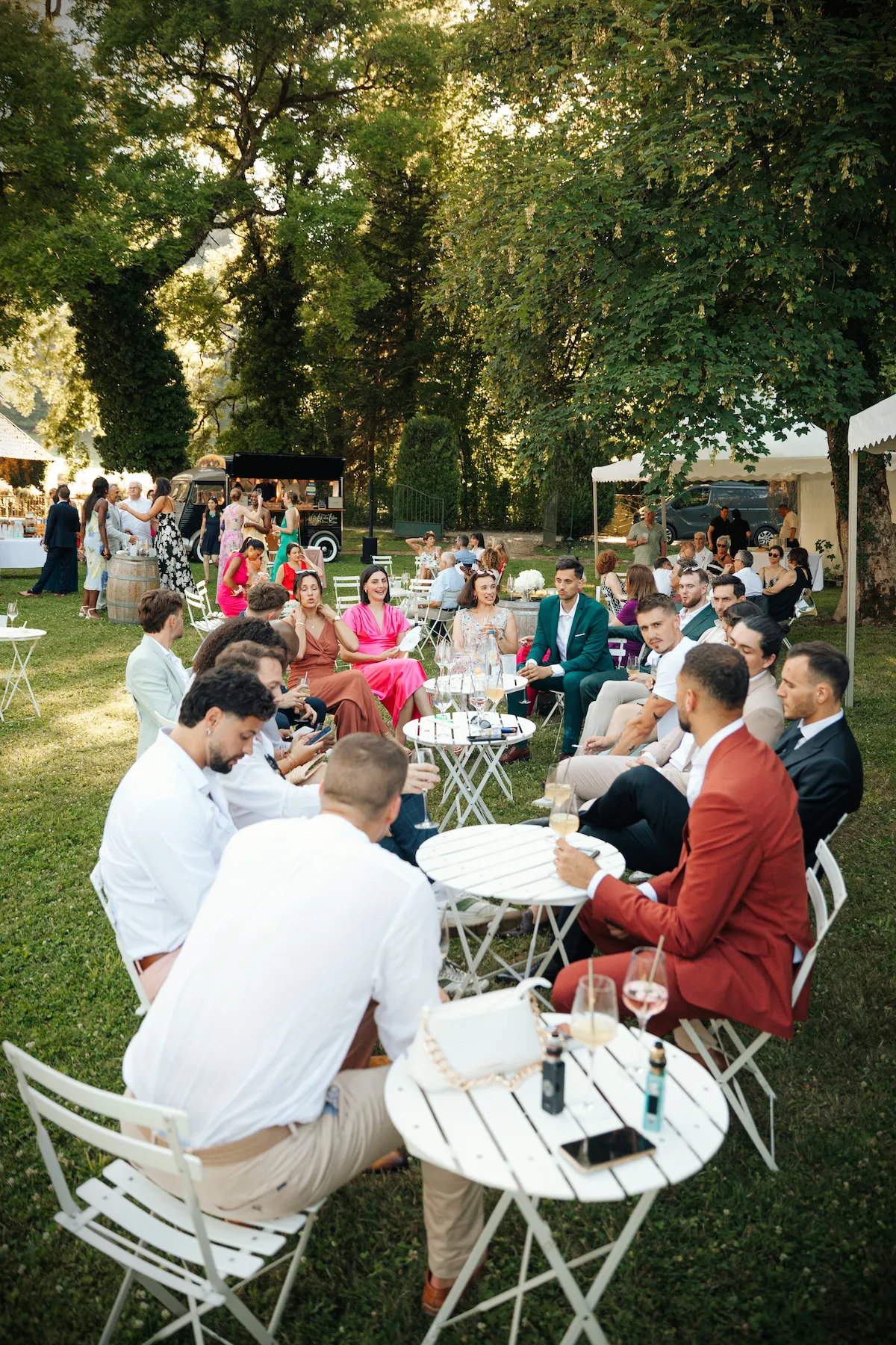 Les invités dégustent leurs cocktails en terrasse sous les arbres, servis par Louise Nomad Bar au Domaine de Guillon