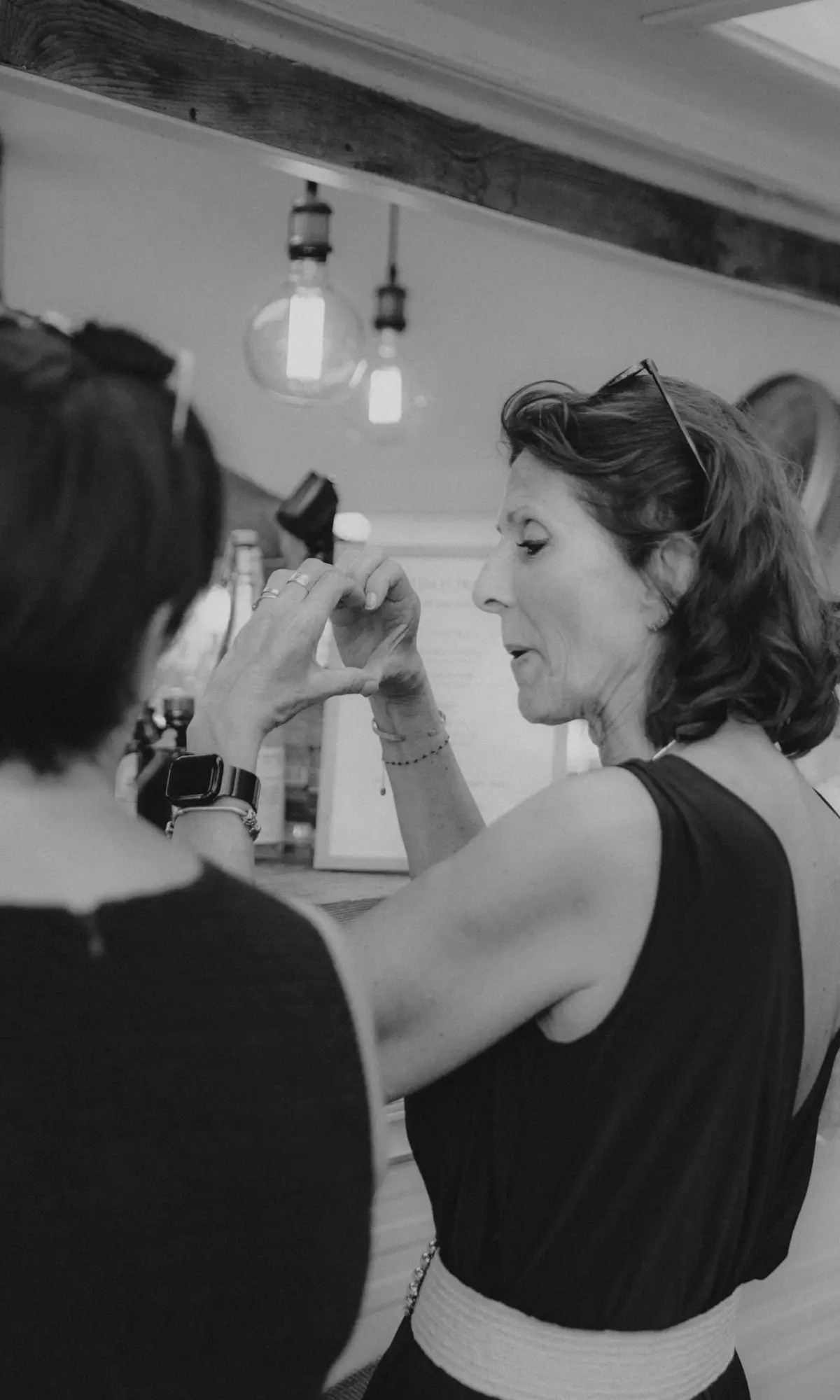 Vue en noir et blanc des invités commandant leurs boissons au bar Louise Nomad Bar pendant le vin d’honneur