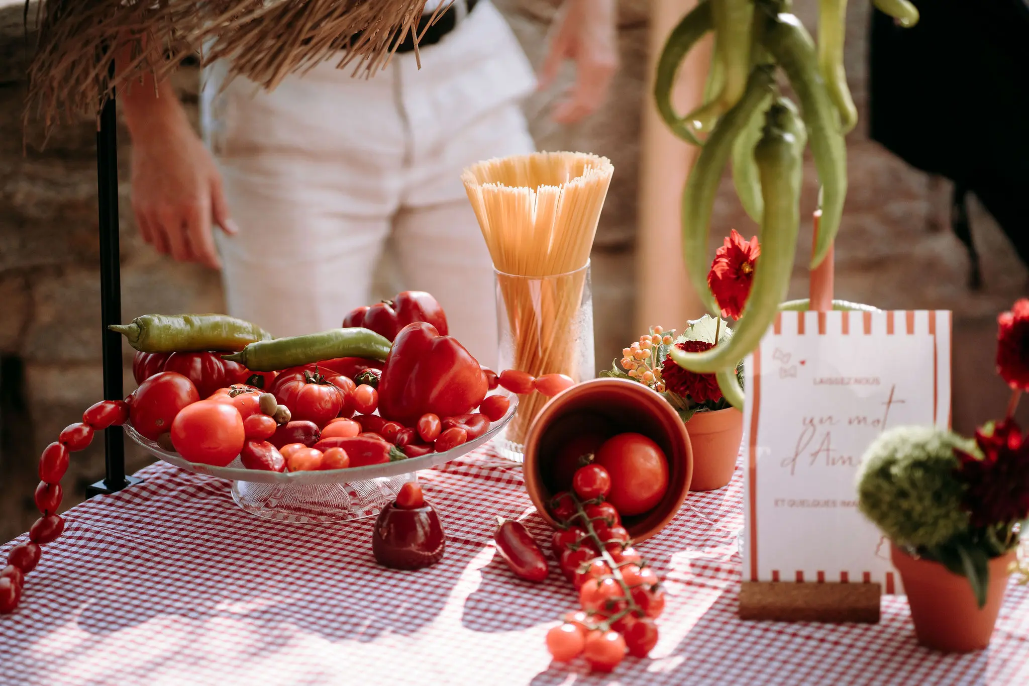Décoration de mariage au Domaine Le Taennel sur le thème italien avec tomates, pâtes et fleurs colorées.