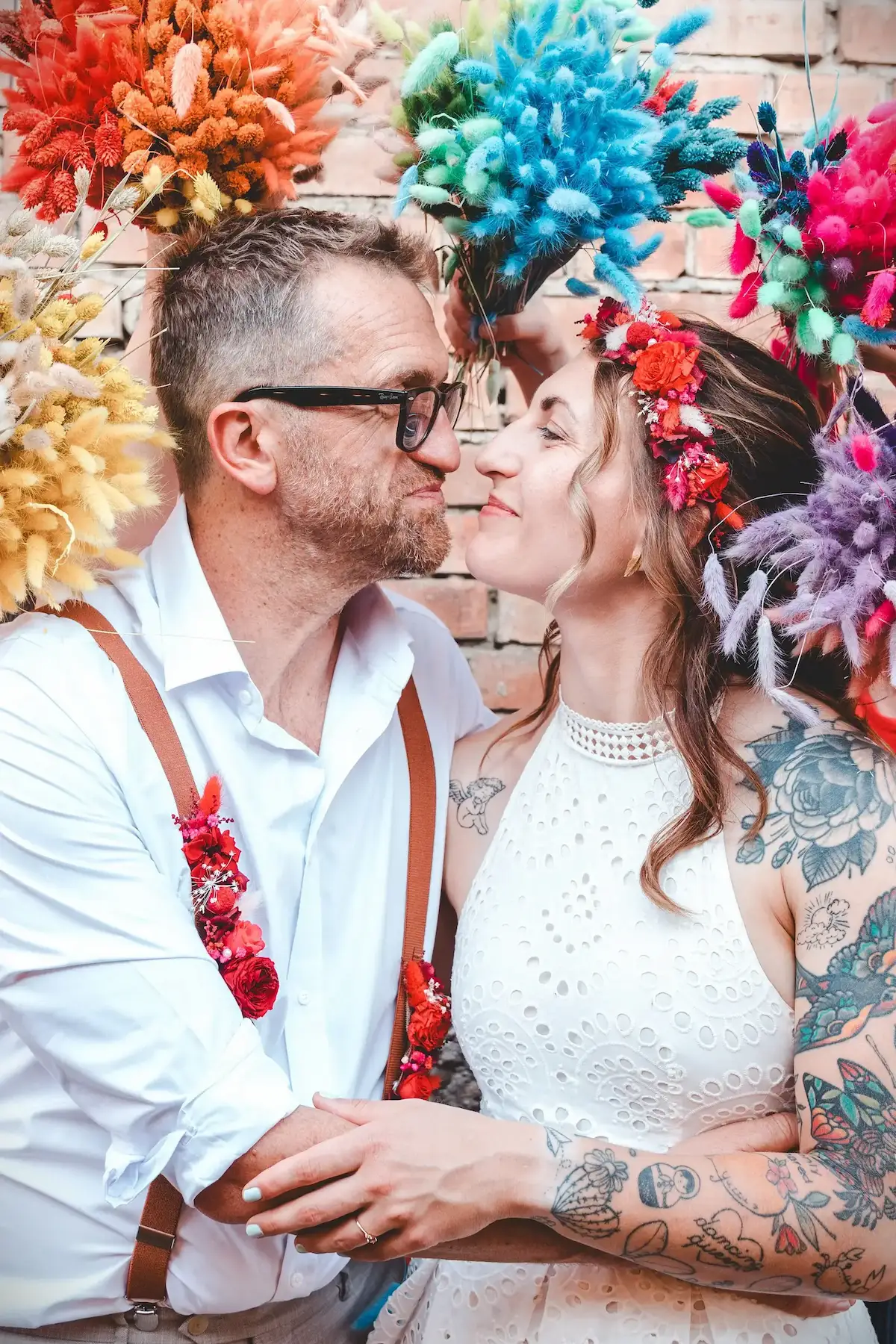 Couple de mariés enlacés devant une décoration colorée – Shooting Wild in Love fête foraine