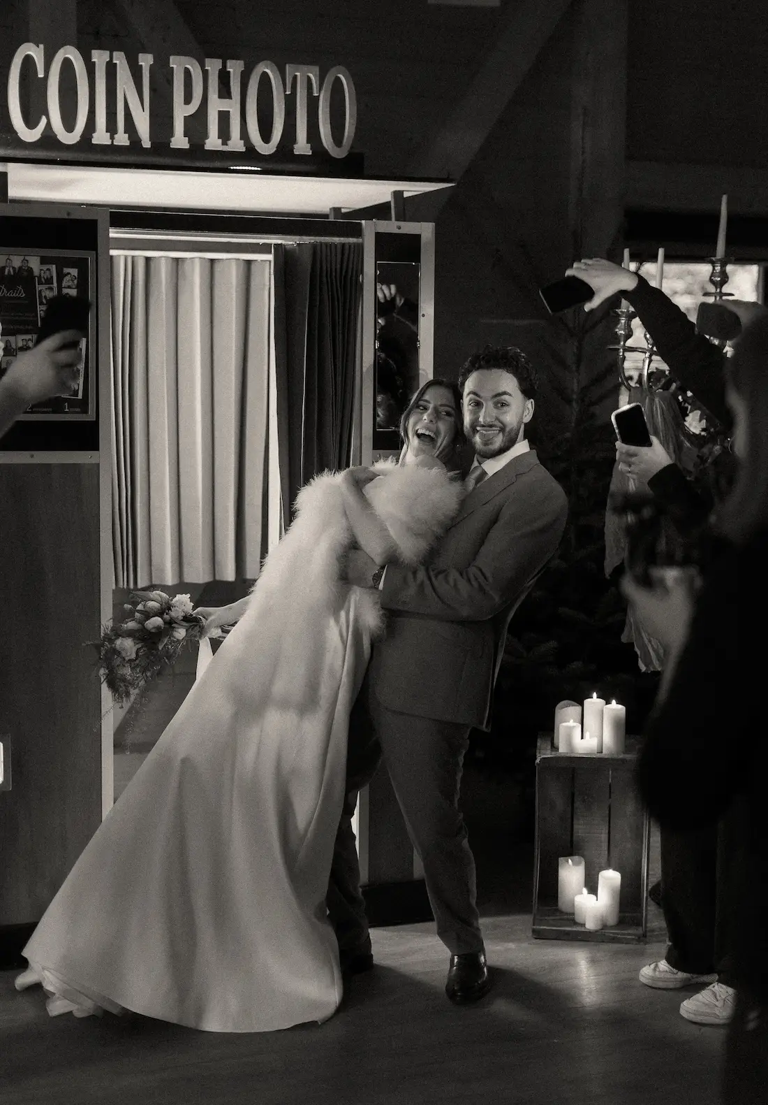 Couple de mariés posant avec énergie devant le coin photo dans une ambiance de mariage hivernale
