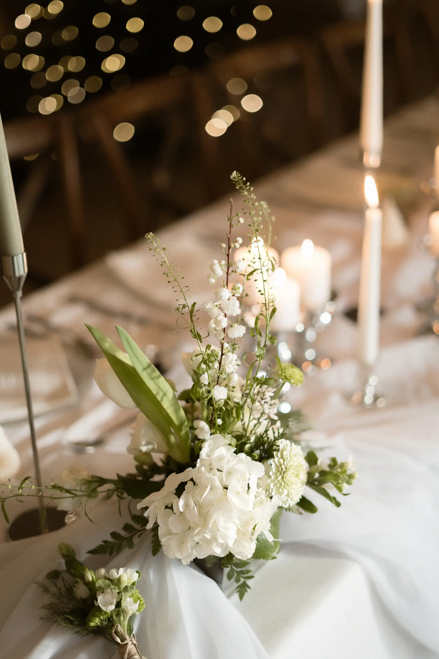 Composition florale blanche et verte sur une table de mariage hivernale au Domaine du Hirtz