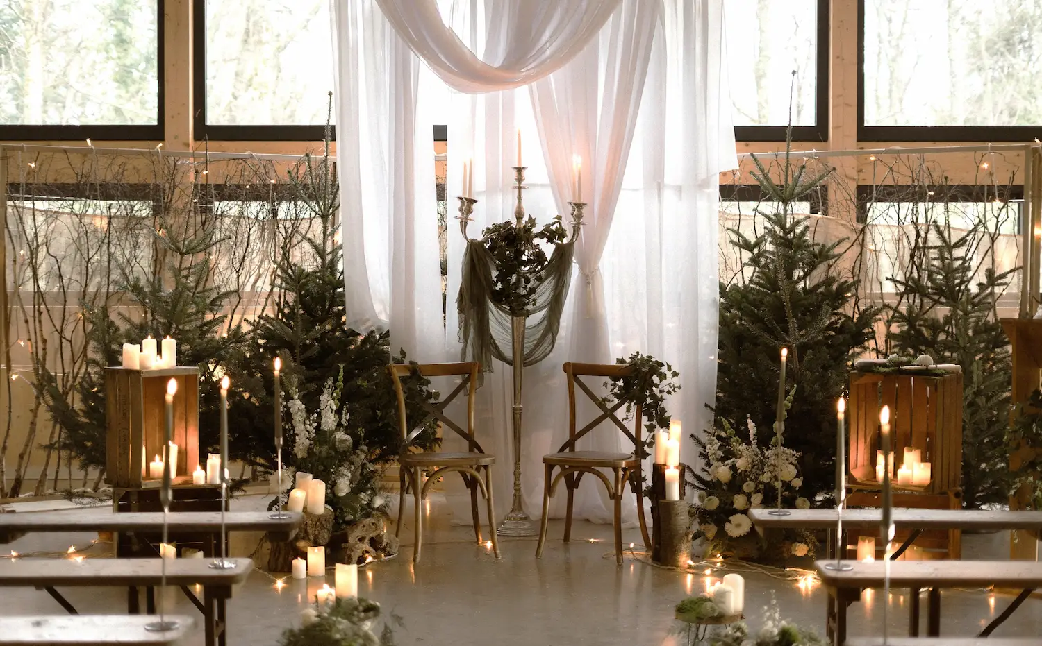 Décoration de cérémonie de mariage hivernale avec chandelles, chaises et mise en scène florale au Domaine du Hirtz