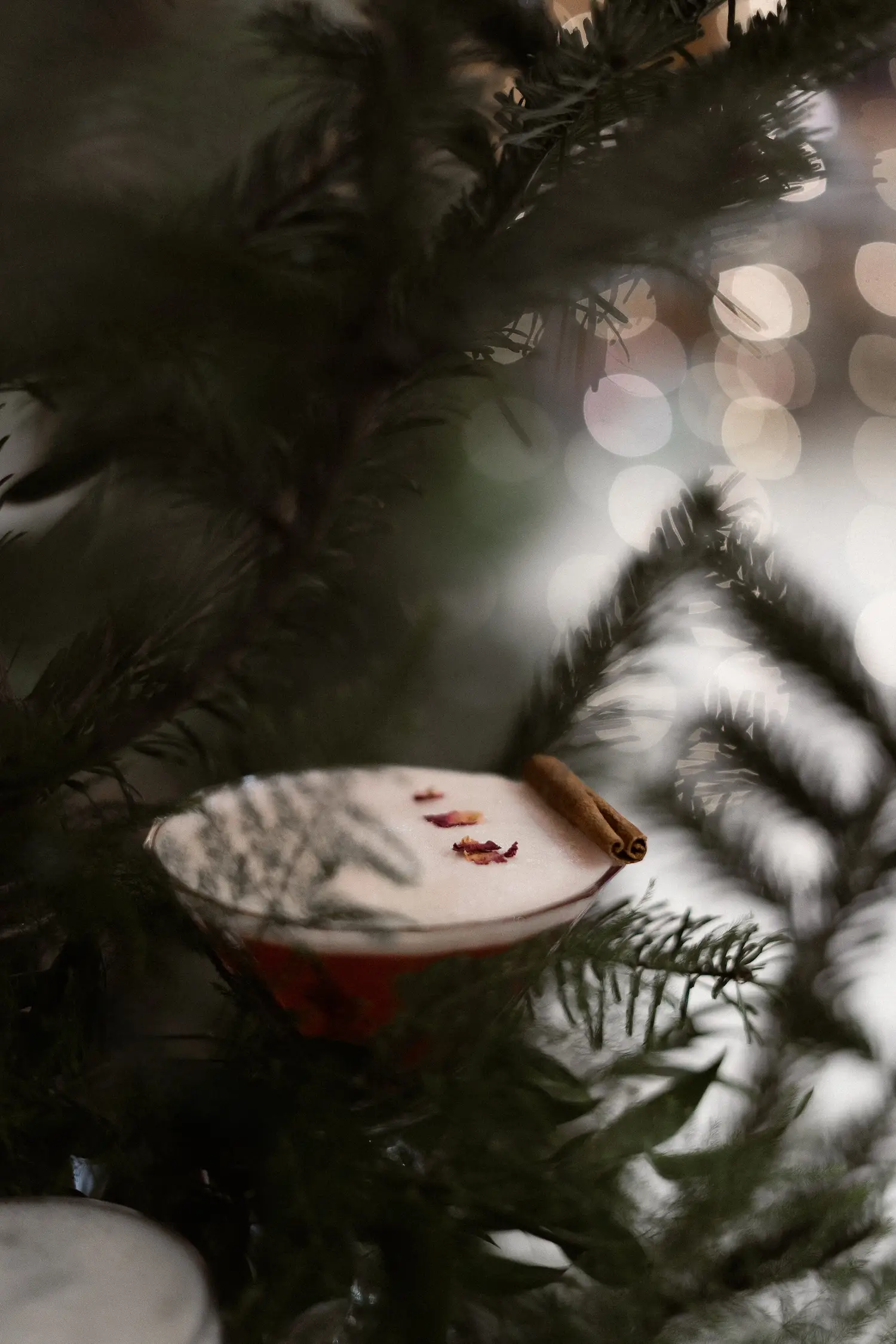 Détail d’une décoration suspendue dans un sapin avec un cocktail de louise nomad bar.
