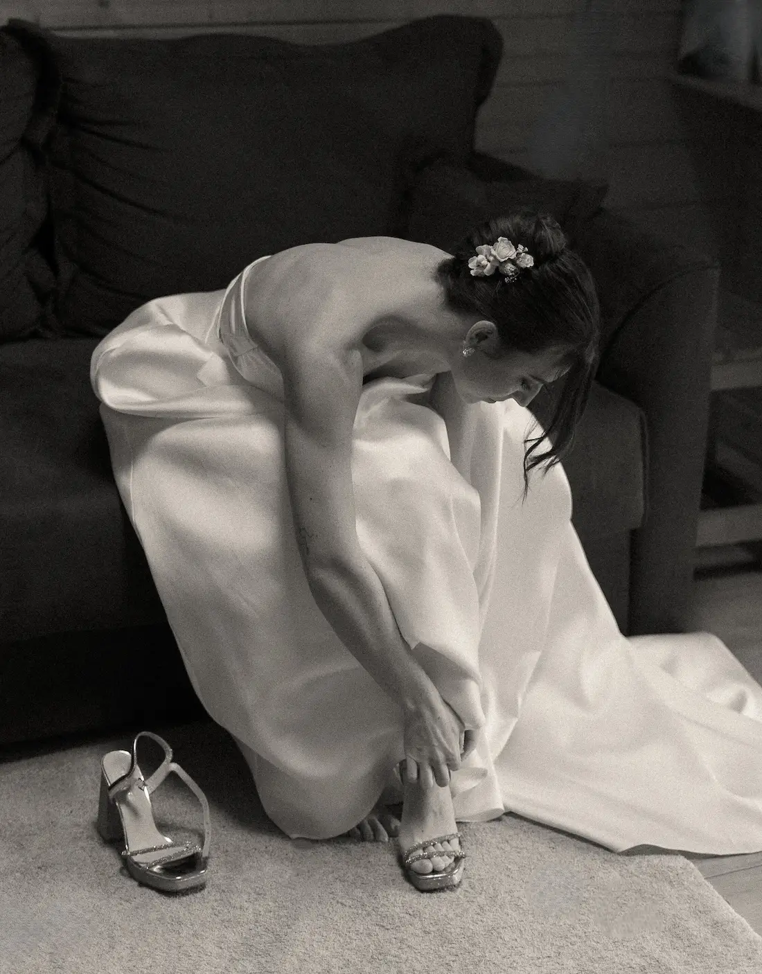 Mariée en robe blanche dans une ambiance intime et élégante avec chaussures argentées