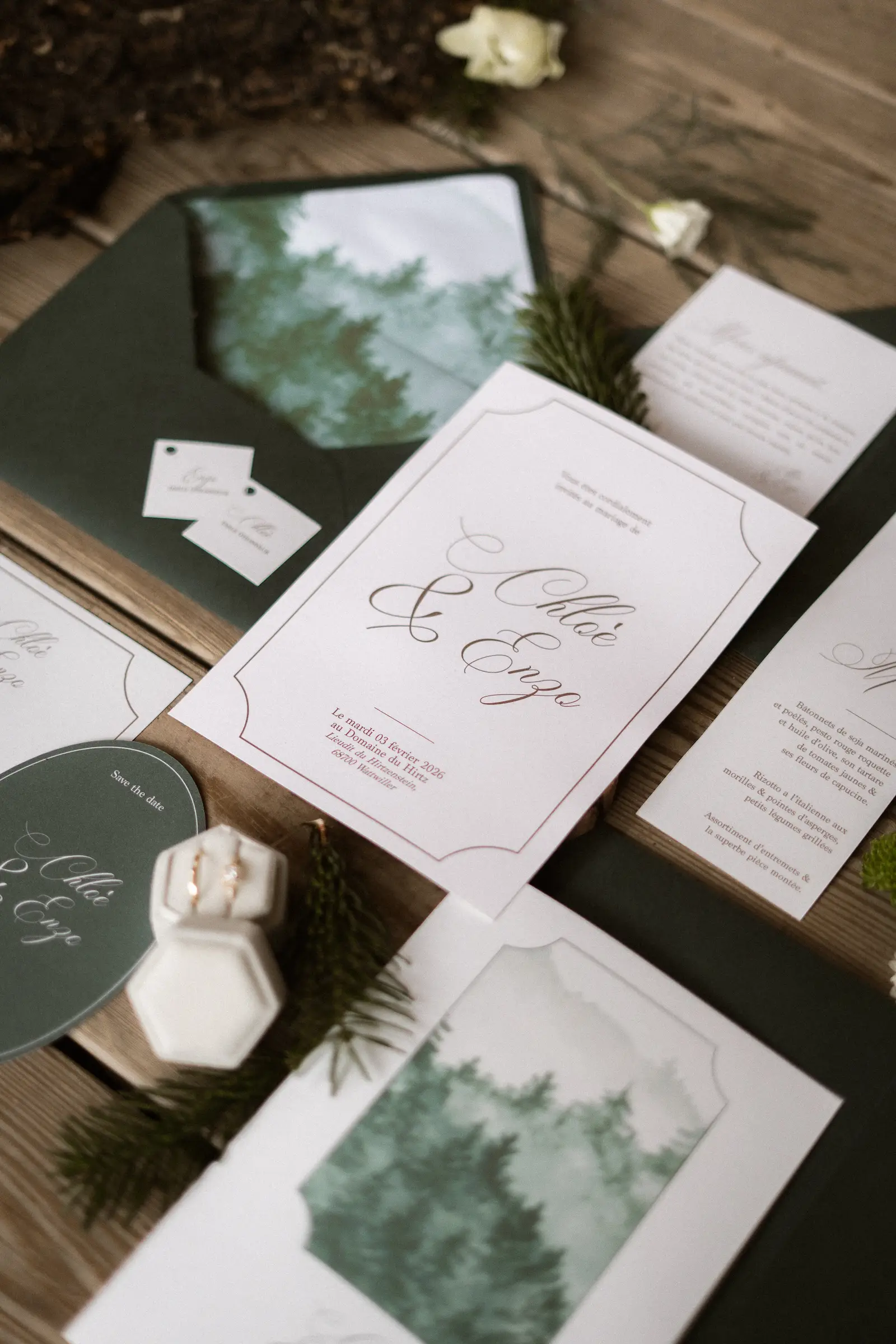 Papeterie de mariage hivernale avec faire-part, enveloppes et détails verts au Domaine du Hirtz